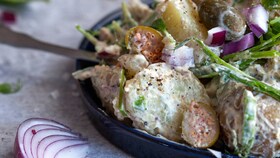 A delicious potato salad mixed with mayonnaise, herbs and red onion