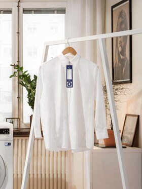 White shirt with a laundry tag hanging up in a living room