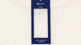 A white woollen jumper with an Electrolux well cared for label