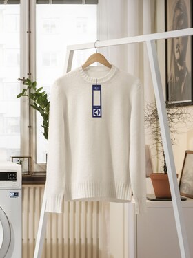 A white woollen jumper hanging up