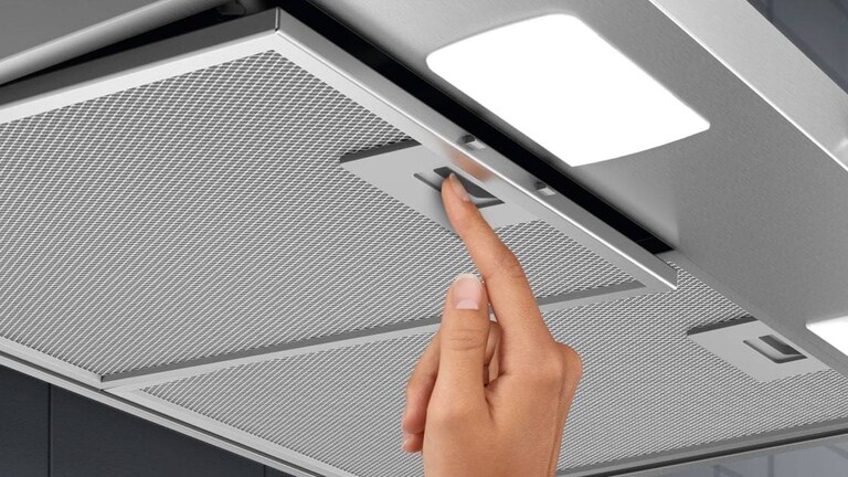 Hand inserting Cooker Hood filter